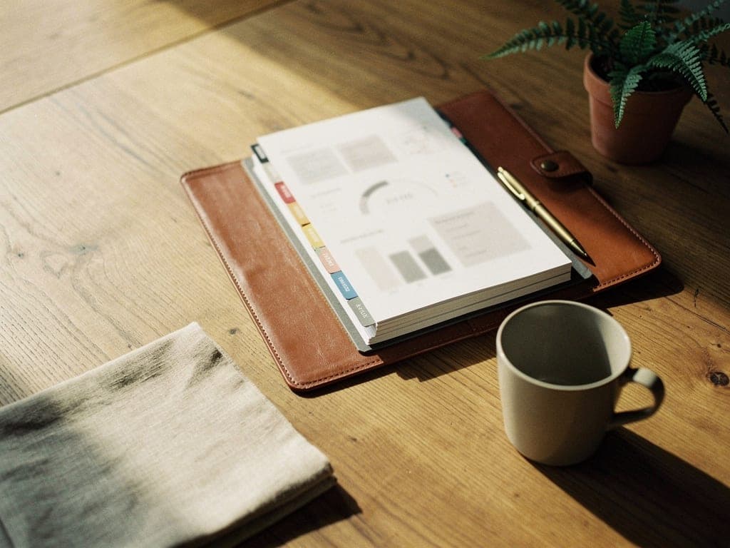 Structured deliverables presented on oak conference table with leather portfolio and KPI materials